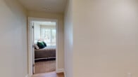 This two-story residence offers a well-organized layout designed for comfortable everyday living. The kitchen is a standout feature, appointed with crisp white cabinetry extending to the ceiling, quartz countertops, a stainless steel gas range, over-the-range microwave, refrigerator, and dishwasher. Light hardwood-style flooring runs through the kitchen and dining area, where recessed lighting and a large window contribute to a bright, open atmosphere. The adjacent living area provides a relaxed setting with recessed lighting and a generously sized window that admits abundant natural light.

The bedrooms are carpeted for warmth and comfort, each featuring large windows with views of surrounding greenery. One bedroom includes a mirrored closet and a sliding glass door, further enhancing the sense of light and openness. The full bathroom is finished with hardwood-style flooring, a tiled soaking tub and shower combination, and a vanity with stone-look countertops. Hallways connect spaces with smooth transitions between wood and carpet flooring. The attached garage offers generous room for vehicle storage. Neutral tones throughout create a cohesive, modern aesthetic across both floors.