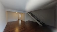 This two-story residence offers a well-organized layout across both levels, finished consistently with rich, dark hardwood flooring that runs throughout the main living areas and bedrooms. The main level features an open living area with a staircase framed by a clean white railing system, leading to the upper floor. Natural light filters in through the front entry door with sidelight, and a vertical blind-covered window brightens the living space further.

The kitchen is outfitted with white cabinetry, granite-look countertops, a stainless steel double-basin sink, a tiled backsplash, and a dishwasher, providing a functional and tidy cooking environment.

A bathroom on the lower level includes a granite-topped vanity with an undermount sink, a framed mirror, and tile flooring. A full bathroom features a soaking tub surrounded by floor-to-ceiling neutral ceramic tile.

The bedrooms are generously sized with hardwood flooring and include closets with double-door or single-door access and built-in rods for storage. One bedroom benefits from a window that admits natural light. Throughout the home, the neutral white walls and clean finishes create a bright, move-in-ready atmosphere that lends itself well to a variety of interior styles.