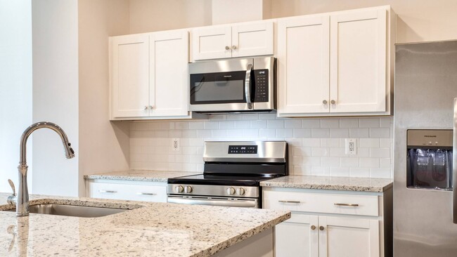 White cabinetry and tile backsplash. - The Mark Townhomes