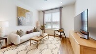 This thoughtfully designed one-bedroom, one-bathroom residence offers a cohesive modern aesthetic throughout its efficiently utilized floor plan. The open-concept kitchen and living area serves as the heart of the home, featuring light wood flat-front cabinetry, stainless steel appliances, a white subway tile backsplash, and granite countertops that extend to a central island with bar seating — ideal for both cooking and casual dining. Warm hardwood-style flooring flows seamlessly through the entire unit, complementing the bright, neutral palette of the walls and trim.

The living area is generously proportioned, benefiting from a large window that invites natural light and provides outdoor views. The bedroom is a comfortable retreat with its own window, ceiling fan, and direct access to the full bathroom. The bathroom features a granite-topped floating vanity, a full soaking tub with shower, and matching hardwood-style flooring that maintains visual continuity.

Storage is a standout feature of this residence, with four closets including a spacious walk-in closet outfitted with wire shelving and hanging rods. A dedicated laundry area and a well-connected hallway round out the practical layout, making this a highly functional and stylish living space.