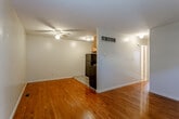 This single-story space at 6808 E 18th St in Kansas City, Missouri, offers a straightforward and functional layout highlighted by warm hardwood flooring that runs throughout the main living areas. The open living area is generously proportioned, providing ample room for furnishings, and is equipped with a ceiling fan for added comfort. Natural light enters through a front door with a transom window and a bedroom window fitted with blinds, lending the space a bright, welcoming feel.

The kitchen is situated adjacent to the living area and features light wood cabinetry with ample upper and lower storage, dark granite-style countertops, a utility sink, and black appliances including a refrigerator and gas range. The flooring transitions to a tile pattern within the kitchen area, clearly defining the space.

The bedroom is a well-sized, quiet room with hardwood floors, neutral walls, and a window that allows natural light to flow in. The bathroom includes a tiled tub and shower surround, a wood vanity with a dark countertop, a toilet, and light tile flooring. Throughout the unit, clean white walls, consistent trim, and a practical layout contribute to a simple and livable overall ambiance.