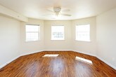 This single-floor residence offers a clean, functional layout designed for comfortable everyday living. The open-concept main area seamlessly connects the living space and kitchen, both finished with warm-toned hardwood-style flooring that runs throughout. A ceiling fan overhead provides added comfort, while recessed lighting keeps the space bright and inviting.

The kitchen is well-equipped with a full suite of stainless steel appliances, including a refrigerator, electric range, built-in microwave, and dishwasher. Warm honey-toned wood cabinetry provides ample storage, and a double-basin sink with a window above brings in natural light. The kitchen's efficient L-shaped layout makes the most of the available space.

Multiple windows throughout the residence allow natural light to flow in and offer views of the surrounding neighborhood. The bedroom features plush wall-to-wall carpeting, a ceiling fan, a window, and an open closet with a hanging rod, providing practical storage.

A utility area houses a full-size side-by-side washer and dryer, with an adjacent toilet room, offering the convenience of in-unit laundry. Neutral wall tones and clean finishes throughout give the space a move-in-ready feel that is easy to personalize.