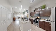 Located at 3819 Harry Wurzbach Rd in San Antonio, Texas, this 2-bedroom, 1-bathroom residence offers a well-designed single-floor layout with a bright, modern aesthetic. The open-concept living area impresses with soaring ceilings, a ceiling fan, and large windows that invite abundant natural light and outdoor views. A bold geometric accent wall adds a striking focal point to the living space, complemented by light wood-style flooring that flows throughout the home.

The kitchen is a standout feature, showcasing rich dark-wood cabinetry, granite countertops, a center island with a undermount sink, and a full suite of stainless steel appliances including a refrigerator, range, microwave, and dishwasher. Stylish pendant lighting and a classic tile backsplash complete the look.

The spacious primary bedroom features a ceiling fan, a large window with exterior views, and ample room for full furnishings. The second bedroom is equally well-appointed with soft lighting and generous space. The bathroom includes a full tub-shower combination, granite-topped vanity with dark cabinetry, open shelving, and light wood-style flooring, maintaining the cohesive design found throughout the residence.
