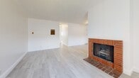 Located at 625-629 N Kenwood St in Glendale, CA, this two-bedroom, two-bathroom residence offers a well-organized single-level layout designed for comfortable everyday living. Light wood-style flooring flows throughout the entire home, complemented by crisp white walls and textured ceilings that create a bright, clean aesthetic.

The living room serves as a welcoming focal point, highlighted by a classic brick fireplace and a wide window that draws in natural light. It connects seamlessly to the dining area and kitchen, which features white cabinetry, a warm mosaic tile backsplash, stainless steel appliances including a gas range and refrigerator, track lighting, and a pass-through counter that opens to the dining space.

Both bedrooms are well-proportioned and naturally lit through large windows with vertical blinds. Each room includes a ceiling fan and dedicated closet space, offering practical storage solutions. The two bathrooms are finished with granite-topped vanities and white cabinetry — one includes a walk-in shower with a frosted glass enclosure, while the other features a full shower-tub combination. The clean, neutral finishes throughout make this a functional and move-in ready home in a convenient Glendale location.
