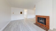 Located at 625-629 N Kenwood St in Glendale, CA, this two-bedroom, two-bathroom residence offers a well-organized single-level layout designed for comfortable everyday living. Light wood-style flooring flows throughout the entire home, complemented by crisp white walls and textured ceilings that create a bright, clean aesthetic.

The living room serves as a welcoming focal point, highlighted by a classic brick fireplace and a wide window that draws in natural light. It connects seamlessly to the dining area and kitchen, which features white cabinetry, a warm mosaic tile backsplash, stainless steel appliances including a gas range and refrigerator, track lighting, and a pass-through counter that opens to the dining space.

Both bedrooms are well-proportioned and naturally lit through large windows with vertical blinds. Each room includes a ceiling fan and dedicated closet space, offering practical storage solutions. The two bathrooms are finished with granite-topped vanities and white cabinetry — one includes a walk-in shower with a frosted glass enclosure, while the other features a full shower-tub combination. The clean, neutral finishes throughout make this a functional and move-in ready home in a convenient Glendale location.
