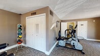 Located at 318 W South Ave in Tampa, FL, this single-floor fitness facility is purpose-built to support a well-rounded workout routine. The space is laid out across an open, carpeted floor plan with warm earth-toned walls that create an energizing yet comfortable atmosphere. Textured ceilings and clean white baseboards give the interior a neat, finished appearance throughout.

The main workout area is generously proportioned, housing a full multi-station cable and weight machine ideal for comprehensive strength training. Complementing this is a rack of medicine balls and a dumbbell rack, offering a variety of resistance training options. True-brand cardio equipment is well represented, with treadmills, an elliptical cross-trainer, and a stationary bike providing ample options for cardiovascular exercise.

Natural light filters in through multiple windows fitted with horizontal blinds, keeping the space bright and airy during daytime hours. A set of French doors opens to the outdoors, enhancing ventilation and providing a pleasant visual connection to the exterior. Motivational fitness artwork adorns the walls, adding character to the environment.

A private restroom is conveniently accessible directly from the fitness area, adding a practical amenity for users. Closet storage is also available within the space. The facility is well-equipped and thoughtfully arranged, making it a functional and inviting destination for fitness in the heart of Tampa.