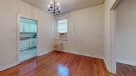 This well-designed 840 square foot apartment maximizes space with 2 bedrooms and 1 bathroom. The primary bedroom, at 190 square feet, offers generous proportions. Throughout the home, gleaming hardwood floors and crisp white walls create a bright, airy atmosphere. Large windows in every room flood the space with natural light, while ceiling fans provide comfort and air circulation. The kitchen, though compact, features white cabinetry and a practical layout. A separate dining area adds functionality. Multiple closets and hallways enhance storage and flow. The bathroom showcases classic white tile and modern fixtures. This apartment effortlessly blends charm and efficiency in its single-floor layout.