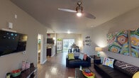 This two-floor residence offers a thoughtfully designed layout that balances communal living spaces with private retreats. The main living area is open and inviting, featuring wood-style flooring, a modern ceiling fan, and direct access to an outdoor patio through sliding glass doors that flood the space with natural light. The living room flows seamlessly into the dining area, which accommodates a full-sized dining table and offers additional patio access and outdoor views.

The kitchen is well-appointed with dark cabinetry, granite-style countertops, black appliances including a range and dishwasher, a double sink, and pendant lighting overhead. Ample cabinet storage makes this a highly functional cooking space.

Multiple bedrooms provide comfortable private quarters, each featuring ceiling fans, carpet flooring, and windows with natural light. The rooms offer sufficient space for a bed, desk, and storage furnishings.

Two full bathrooms serve the residence, each featuring a shower-tub combination, a vanity with storage, and tile-style flooring. A dedicated in-unit laundry room houses a stacked washer and dryer alongside open shelving, adding notable everyday convenience to this well-rounded home.