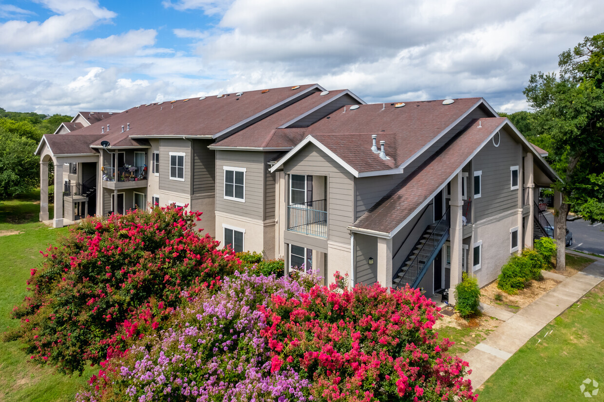 Amplio complejo de apartamentos con jardines exuberantes y flores vibrantes en Avonmora en Austin - Avonmora Apartments