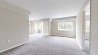 Located at 5613 Regency Park Ct in Suitland, Maryland, this single-floor residence offers four bedrooms and one bathroom within a efficiently arranged floor plan. The layout flows from a dedicated entrance through a central hallway that connects all primary spaces.

The living room is among the most prominent spaces in the home, featuring plush carpeting, neutral-toned walls, and an abundance of natural light drawn in through large sliding glass doors and a wide picture window. The sliding doors provide outdoor access and views of surrounding greenery, creating an open, airy atmosphere.

The kitchen is designed in a galley configuration, featuring rich dark wood cabinetry, granite-look countertops, wood-look flooring, and white appliances including a refrigerator and dishwasher. The four carpeted bedrooms are finished in neutral tones with white trim. The primary bedroom is notably spacious and includes a double-door closet. Several bedrooms offer windows with pleasant outdoor views of landscaped green areas. The bathroom includes a full soaking tub and shower combination. Throughout the home, consistent neutral wall colors, white trim, and soft carpeting create a cohesive and understated aesthetic.