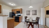 Located at 5744 Thorton St in Columbus, Ohio, this single-floor residence offers a well-designed, open-concept layout that seamlessly connects the main living areas. The spacious living room features plush carpeting, generous natural light, and a sliding glass door that opens to a private balcony, providing a comfortable indoor-outdoor connection.

Adjacent to the living room, the dining area accommodates an intimate dining setup beneath a stylish pendant light, with a convenient pass-through to the kitchen. A door nearby reveals an in-unit laundry area, adding everyday practicality. The kitchen is well-appointed with warm wood cabinetry, granite-style countertops, hardwood flooring, and a full suite of black appliances including a refrigerator, range, microwave, and dishwasher.

The bedrooms are carpeted and finished in neutral tones, each offering closet storage — one features a walk-in-style closet with shelving. The two bathrooms are finished with large-format tile flooring, warm wood vanities topped with granite-style counters, and well-lit mirrors. One bathroom includes a walk-in shower, while the other features a shower-tub combination.

Throughout the residence, a consistent neutral color palette and clean finishes create a calm, cohesive atmosphere suited for comfortable everyday living.