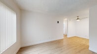 Located at 203 Laurel Ave in National City, CA, this single-story 1-bedroom, 1-bathroom unit offers a thoughtfully designed layout that maximizes every square foot. Light wood-style flooring runs continuously throughout the space, complemented by crisp white walls and textured ceilings that create a clean, cohesive aesthetic.

The living room is bright and open, featuring a ceiling fan and a large window with vertical blinds that allows natural light to fill the space. A wall-mounted intercom panel adds a functional touch near the entry.

The kitchen is laid out in a galley style, offering ample white cabinetry with brushed nickel hardware, white quartz-style countertops, a deep stainless steel sink with a pull-down faucet, and stainless steel appliances including a refrigerator, electric range, and range hood. A skylight overhead enhances the brightness of the workspace.

The bedroom is a comfortable size, featuring a window with views to the exterior and a sliding-door closet with built-in shelving and hanging rods, providing generous storage.

The bathroom is finished with a white vanity cabinet, a white stone-top sink, brushed nickel fixtures, a large mirror, and coordinating towel rings, all set atop the same warm wood-style flooring found throughout the unit.