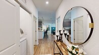 Located at 107 Bayvista Dr in Port Royal, SC, this well-appointed two-bedroom, two-bathroom residence offers a thoughtfully designed single-floor layout with consistent modern finishes throughout. Wood-look flooring runs continuously through the space, creating a cohesive and easy-to-maintain foundation in every room.

The entryway sets a welcoming tone, opening to a corridor that connects the main living areas. The living room is a standout space, featuring a bold teal half-wall accent, a ceiling fan, and French doors that open to a private balcony with outdoor views, flooding the room with natural light.

The kitchen is well-equipped with gray flat-front cabinetry extending to the ceiling, granite countertops, a white subway tile backsplash, stainless steel appliances, and a peninsula with pendant lighting—ideal for both cooking and casual dining.

The primary bedroom is a generous, comfortable retreat with a ceiling fan, ample natural light, and a closet with built-in shelving. Its en-suite bathroom features a double granite vanity, glass-enclosed walk-in shower, and wood-look flooring. The second bedroom is equally bright, with a ceiling fan and large windows. The second bathroom offers a granite vanity and a tub-shower combination.
