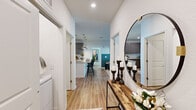 Located at 107 Bayvista Dr in Port Royal, SC, this well-appointed two-bedroom, two-bathroom residence offers a thoughtfully designed single-floor layout with consistent modern finishes throughout. Wood-look flooring runs continuously through the space, creating a cohesive and easy-to-maintain foundation in every room.

The entryway sets a welcoming tone, opening to a corridor that connects the main living areas. The living room is a standout space, featuring a bold teal half-wall accent, a ceiling fan, and French doors that open to a private balcony with outdoor views, flooding the room with natural light.

The kitchen is well-equipped with gray flat-front cabinetry extending to the ceiling, granite countertops, a white subway tile backsplash, stainless steel appliances, and a peninsula with pendant lighting—ideal for both cooking and casual dining.

The primary bedroom is a generous, comfortable retreat with a ceiling fan, ample natural light, and a closet with built-in shelving. Its en-suite bathroom features a double granite vanity, glass-enclosed walk-in shower, and wood-look flooring. The second bedroom is equally bright, with a ceiling fan and large windows. The second bathroom offers a granite vanity and a tub-shower combination.