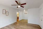 Located at 700 Hickory Dr in Huntsville, Texas, this efficiently designed one-bedroom, two-bathroom unit offers a practical and comfortable single-floor layout. The open combined living and dining area is a welcoming centerpiece, featuring warm wood-look laminate flooring, crisp white walls, and a ceiling fan with light fixture overhead. A large sliding glass door floods the space with natural light and provides outdoor access. The galley-style kitchen is well-equipped with white cabinetry, granite-look countertops, and white appliances including a refrigerator and range, complemented by a pantry for additional storage. The bedroom is carpeted for comfort, benefits from a ceiling fan, and is brightened by a window with natural light. Two closets provide ample storage throughout the unit. Both bathrooms are functional and clean; one features a tiled tub/shower surround with neutral beige tilework and chrome fixtures, while the other includes a vanity with granite-look countertops, under-sink storage, and a large mirror. A hallway connects the private areas of the unit seamlessly. The consistent use of light tones and wood-look flooring throughout the common areas creates a cohesive, clean aesthetic suited for comfortable everyday living.