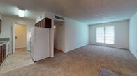 Located at 104 Ellen Ct in Summerville, SC, this single-floor unit offers a practical and well-organized layout across several connected living spaces. The open living and dining area is finished with neutral-toned wall-to-wall carpeting and ceiling fans with integrated lighting, creating a comfortable, airy atmosphere. Natural light filters in through multiple windows fitted with blinds, offering views of the surrounding greenery.

The galley-style kitchen is efficiently designed with rich, dark wood cabinetry, granite-look countertops, tile flooring, and white appliances including a coil-top range, dishwasher, and full-size refrigerator. A dedicated laundry connection is conveniently located just off the kitchen.

The bedrooms are carpeted and well-proportioned, each featuring ceiling fans, windows with natural light, and closets with bi-fold doors for organized storage. The neutral color palette throughout the bedrooms contributes to a calm and versatile environment.

The bathroom includes tile flooring in a stone-look finish, a wall-mounted sink, standard fixtures, a vanity mirror with overhead lighting, and a bathtub with an accessibility grab bar. The overall design of this unit prioritizes functionality and comfort, making it a practical living space in the Summerville community.