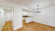Located at 1100 W Huntington Dr in Arcadia, CA, this well-appointed 2-bedroom, 2-bathroom single-story residence offers a clean, modern aesthetic throughout its thoughtfully designed floor plan. Warm-toned hardwood flooring flows seamlessly across every room, complementing the bright white walls and creating a cohesive, inviting atmosphere.

The kitchen is a standout feature, showcasing white shaker-style cabinetry with matte black hardware, rich granite countertops, stainless steel appliances including a built-in oven and dishwasher, and a peninsula that opens directly into the dining area. A stylish black chandelier anchors the dining space, adding a contemporary touch. Recessed lighting throughout the kitchen ensures a well-lit cooking environment.

The living room is bright and airy, with a large window that draws in natural light and offers views of the surrounding greenery. Both bedrooms are generously sized, with the spacious primary bedroom featuring a ceiling fan with light fixture and large windows. The second bedroom also benefits from natural light and closet access. Four closets throughout the home provide ample storage.

The bathrooms are clean and functional, featuring a full tub-shower combination with built-in shelving. Additional highlights include a dedicated laundry area, a hallway connecting the living spaces, and a private patio for outdoor enjoyment.