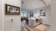 This thoughtfully designed one-bedroom, one-bathroom residence in Melbourne, Florida offers a seamless open-concept layout that connects the kitchen, dining, and living areas into a cohesive, light-filled space. Wide-plank wood-look flooring flows throughout, lending a warm, contemporary aesthetic to every room.

The kitchen is a standout feature, boasting two-tone cabinetry in white and soft grey, quartz countertops, a stainless steel farmhouse sink, a sleek range hood, and stainless steel appliances including a refrigerator and double wall oven. An island provides additional prep and dining space. The living room is bright and inviting, with large windows and a ceiling fan that draw in natural light and outdoor views.

The bedroom is a comfortable retreat, accommodating a generous bed, with natural light streaming through well-appointed windows dressed with patterned drapes and a ceiling fan overhead.

The bathroom features a double-sink vanity with grey cabinetry, a glass-enclosed walk-in shower, open shelving, and wood-look tile flooring. Additional conveniences include a dedicated in-unit laundry room with full-size washer and dryer, a pantry, a hallway, a closet, and a private balcony — rounding out a well-equipped, functional floor plan.