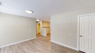 Located at 1008 Rucker St in Greensboro, NC, this single-story, one-bedroom, one-bathroom unit offers a clean and functional layout with modern updates throughout. Light wood-style flooring runs continuously across the entire space, complemented by neutral beige-toned walls and crisp white trim, creating a cohesive and welcoming atmosphere.

The combined kitchen and living area forms the heart of the home. The kitchen is well-appointed with white shaker-style cabinetry, marble-patterned countertops, a stainless steel sink, and a full suite of stainless steel appliances including a refrigerator, electric range, over-the-range microwave, and dishwasher. Flush-mount lighting and a skylight brighten the kitchen, enhancing the clean aesthetic.

The living area provides an open, versatile space with two doorways offering connectivity to the rest of the unit. The bedroom is comfortably sized, featuring a window with blinds that allows natural light and outdoor views of surrounding greenery. A dedicated closet offers convenient storage.

The bathroom includes a walk-in shower with grab bars, a single-handle fixture, and a floating wood-toned vanity with a white countertop surface. Throughout the unit, the design emphasizes simplicity, functionality, and a move-in-ready condition.
