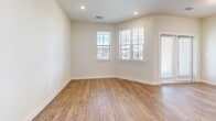 Located at 7121 Elroy St in Austin, TX, this single-story 2-bedroom, 2-bathroom home offers a well-designed layout with modern finishes throughout. Warm wood-look flooring flows consistently across the entire home, complementing the neutral, light-toned walls that create a clean and cohesive aesthetic.

The open kitchen and living area serves as the heart of the home. The kitchen is appointed with white shaker-style cabinetry, stainless steel appliances including a refrigerator, range, and over-the-range microwave, and a large central island topped with granite countertops and an undermount sink — ideal for both meal prep and casual dining. Recessed lighting illuminates the space efficiently.

The living room benefits from multiple windows fitted with horizontal blinds, allowing natural light to fill the room while maintaining privacy. Both bedrooms are comfortably sized, each featuring large windows with outdoor views and dedicated closets. The primary bedroom includes a ceiling fan and connects to a full bathroom with a double-sink granite vanity, white cabinetry, and a tub-shower combination with subway tile surround. The second bathroom mirrors the same clean, white design aesthetic.

A dedicated laundry nook with built-in shelving and washer/dryer hookups adds everyday convenience, completing this thoughtfully laid-out Austin home.
