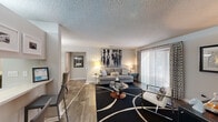 Located at 1507 Pine Dr in Atlanta, GA, this single-floor, 2-bedroom, 3-bathroom home offers a well-designed layout with a cohesive, contemporary aesthetic throughout. Wood-style flooring runs through the main living areas, complemented by neutral gray tones and textured ceilings that add character to each room.

The living room is generously proportioned, featuring large sliding glass doors that invite natural light and offer views of the outdoors. The adjacent dining area is defined by an elegant pendant light fixture and mirrored wall accents, creating a refined space for entertaining. The kitchen is visible from the dining room and features dark cabinetry with a tile backsplash.

The primary bedroom is a comfortable retreat with plush carpet, a ceiling fan with integrated lighting, and direct access to an en-suite bathroom featuring dark wood cabinetry and hardwood-style flooring. The second bedroom also features carpet, a ceiling fan, and a bright window with decorative drapery. Three full bathrooms serve the home, ensuring ample convenience.

A dedicated hallway connects the living spaces to the private quarters, and a separate laundry room houses full-size washer and dryer units with built-in shelving overhead. The overall ambiance is modern and move-in ready, blending functionality with stylish design details throughout.