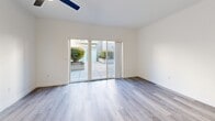 Located at 255 W Broadway in Eugene, Oregon, this thoughtfully designed one-bedroom, one-bathroom unit offers a bright and modern living experience across a single floor. The open-concept kitchen and living area serves as the heart of the space, featuring a galley-style kitchen outfitted with stainless steel appliances — including a refrigerator, range, microwave, and dishwasher — two-tone cabinetry with white uppers and gray lowers, and clean white countertops. A skylight overhead floods the kitchen with natural light. The living area is spacious and airy, with light gray wood-style flooring running throughout the unit, recessed lighting, a ceiling fan, and large sliding glass doors that open directly onto a private outdoor patio, bringing in abundant natural light and outdoor views. The bedroom is comfortably sized, offering a dedicated closet with built-in shelving and a window that overlooks lush greenery. The bathroom features a full tub-shower combination, white vanity, and brushed gold hardware accents. Crisp white walls and consistent flooring create a clean, cohesive aesthetic throughout, making this a well-appointed and move-in ready space in the heart of Eugene.