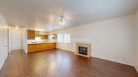 Located at 2300 Riverview Drive in Madera, CA, this single-story, 2-bedroom, 2-bathroom home offers a well-designed layout with a comfortable and functional floor plan. The open-concept living and dining area serves as the heart of the home, featuring rich hardwood-style flooring, a ceiling fan with light fixture, and a tile-surround fireplace that adds warmth and character to the space. Large windows allow natural light to fill the room, creating a bright and inviting ambiance. The U-shaped kitchen is well-appointed with warm oak cabinetry, light countertops, a double-basin sink, and white appliances including a range, dishwasher, and refrigerator. Multiple windows bring in additional natural light, making the kitchen feel open and airy. Both bedrooms are carpeted and offer a quiet retreat, with the primary bedroom featuring generous closet space, including a walk-in closet with built-in shelving. The bathrooms are finished with matching oak vanity cabinetry and hardwood-style flooring. Additional highlights include four closets for ample storage, a dedicated laundry area, a utility room, a hallway connecting the private spaces, and a balcony for outdoor enjoyment.