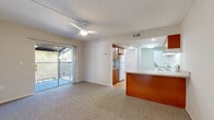 Located at 1448 Adriel Lane in Orlando, FL, this one-bedroom, one-bathroom residence offers a thoughtfully laid-out single-floor plan. The open-concept living, dining, and kitchen area serves as the heart of the home, featuring plush carpeting, a ceiling fan, and a sliding glass door that leads to a private balcony with outdoor views—filling the space with natural light.

The kitchen is well-appointed with warm honey-toned wood cabinetry, granite-look countertops, a peninsula breakfast bar, and a full suite of white appliances including a refrigerator, electric range, dishwasher, and an in-unit stacked washer and dryer. Wood-look flooring anchors the kitchen, adding warmth and easy maintenance.

The bedroom offers a comfortable retreat with plush carpeting, a ceiling fan, and a wide window dressed with blinds that frame views of surrounding greenery. A dedicated closet provides ample storage, and access to the full bathroom is conveniently nearby.

The bathroom features matching wood cabinetry with granite countertops, a framed mirror, and wood-look flooring, consistent with the overall design aesthetic of the home. Clean, neutral wall tones throughout the residence create a bright, inviting ambiance suited for comfortable everyday living.