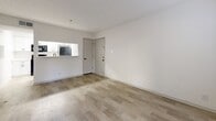 Located at 3078 Clairmont Rd NE in Brookhaven, GA, this one-bedroom, one-bathroom unit offers a well-organized, efficient layout across a single floor. The open-concept living room is bright and airy, featuring light wood-style flooring, neutral white walls, a textured ceiling, and French doors that invite natural light and provide access to an outdoor area. A large window further enhances the natural light in the living space.

The galley-style kitchen is thoughtfully designed with white shaker cabinetry accented by black hardware, light quartz countertops, a stainless steel sink with a matte black faucet, and a suite of appliances including a dishwasher, range, and microwave. Light wood-style flooring continues throughout the kitchen, maintaining a cohesive aesthetic.

The bedroom offers soft carpeting underfoot, a ceiling fan with integrated lighting, and a window with blinds that provides natural light. A dedicated closet adds practical storage. The full bathroom features a clean, all-white tiled tub and shower combo, a white vanity with sink, and light wood-style flooring with contrasting black fixtures and hardware. An in-unit laundry area completes the practical amenities of this efficiently designed Brookhaven residence.