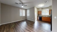 Located in Los Angeles, CA (91342), this single-floor residence offers a thoughtfully designed layout with a clean, modern aesthetic throughout. The open living and dining area is anchored by rich, dark hardwood-style flooring that extends seamlessly through the main living spaces, complemented by neutral taupe walls and white baseboards that create a bright, cohesive feel. Ceiling fans are present in multiple rooms, ensuring year-round comfort. Large windows dressed with vertical blinds invite generous natural light into the living area, which also benefits from track lighting for added ambiance.

The kitchen is well-equipped and functional, featuring warm wood cabinetry that extends to the ceiling for ample storage, dark granite-style countertops, a stainless steel double sink, and a full suite of black appliances including a range, over-the-range microwave, and refrigerator. The bedroom offers plush carpeting, a ceiling fan, a window with vertical blinds, and a calm, restful atmosphere. The bathroom is neatly appointed with a wood-toned vanity, a large mirror with overhead lighting, a combined tub and shower, and hardwood-style flooring. The property also benefits from mature trees and accessible parking immediately outside.