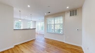 This well-designed single-floor residence offers a clean, modern aesthetic throughout, highlighted by warm honey-toned hardwood flooring that flows seamlessly across the main living areas and bedrooms. The open-concept living and dining area is filled with natural light, courtesy of multiple large windows fitted with white blinds that frame greenery-filled outdoor views. Recessed lighting and elegant pendant fixtures above the kitchen bar add a polished touch to the space.

The kitchen is thoughtfully equipped with a full suite of stainless steel appliances, including a gas range, over-the-range microwave, French door refrigerator, and dishwasher. Light maple cabinetry paired with dark granite countertops creates a classic contrast, while a raised breakfast bar connects the kitchen to the living area.

The bedrooms are generously sized, each featuring hardwood floors and large windows that invite natural light and treetop views. A hallway connects the rooms, offering a practical and efficient layout.

The bathrooms are finished with light tile flooring, white cabinetry, dark granite vanity tops, and oval mirrors, lending a clean and functional design. Brushed nickel hardware and accessibility grab bars are consistent throughout.

Overall, the space presents a bright, move-in-ready environment with cohesive finishes and abundant natural light.