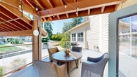 Located in Vancouver, WA, this generously sized single-floor community space offers a well-designed, open-plan layout ideal for gatherings and shared activities. The expansive main area flows seamlessly between a fully equipped kitchen, multiple dining zones, and comfortable lounge areas, all unified by warm wood-tone flooring and neutral, inviting wall tones throughout.

The kitchen is a standout feature, showcasing rich dark cabinetry, striking granite countertops across extended island and perimeter surfaces, dual undermount sinks, and a tasteful mosaic tile backsplash. Ample recessed lighting and multiple windows ensure the kitchen remains bright and functional.

The dining area accommodates several tables and chairs beneath ceiling fans, with large windows dressed in Roman shades offering pleasant outdoor views and abundant natural light. Crown molding and white chair-rail detailing add a refined architectural touch to each room.

A dedicated lounge or sitting area provides a quieter retreat, furnished with accent chairs and decorative shelving, while a separate nook offers an intimate space for smaller gatherings. Throughout, ceiling fans and recessed lighting maintain a comfortable ambiance.

The covered outdoor balcony extends the living space outside, featuring exposed wood-beam ceilings, bistro string lights, wicker seating, and views of surrounding greenery — a welcoming spot for relaxation or outdoor dining.