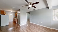 Located on Beach Blvd in Jacksonville, FL, this single-floor, 2-bedroom, 1-bathroom home offers a practical and cohesive layout designed for comfortable everyday living. Consistent warm-toned hardwood-style flooring and cool gray-blue walls run throughout, creating a unified and calming aesthetic across all rooms.

The open living room serves as the heart of the home, featuring a ceiling fan with light fixture and a textured ceiling. A structural beam adds a subtle architectural detail overhead, and ample wall outlets are positioned throughout for convenience.

The galley-style kitchen is efficiently laid out with warm wood cabinetry, granite-look countertops, a stainless steel double sink, and white appliances including a range and refrigerator. A door with a charming arched transom window provides natural light and direct exterior access.

Both bedrooms are well-sized and bright, each equipped with ceiling fans and multiple windows fitted with blinds that invite natural light and views of surrounding greenery. The primary bedroom offers generous space and multi-window corner exposure.

The full bathroom is thoughtfully equipped with accessibility-friendly grab bars near the tub and toilet, a wood-toned vanity with matching countertop, a tub-shower combination, and a small window for ventilation. The home's consistent finishes and functional design make it a practical and inviting residence.