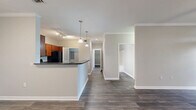 Located at 9404 West Rd in Houston, TX, this single-story, 2-bedroom, 3-bathroom home offers a well-designed layout with modern finishes throughout. Rich hardwood-style flooring flows consistently across the living spaces, complemented by neutral gray tones and clean white trim that create a bright, cohesive aesthetic.

The open-concept living room features crown molding, a ceiling fan, and large windows that invite abundant natural light and outdoor views of surrounding greenery. It connects seamlessly to the kitchen, which is equipped with warm cherry wood cabinetry, dark granite countertops, a breakfast bar peninsula with pendant lighting, and black appliances — including a range, microwave, and refrigerator. Track lighting overhead adds a functional, stylish touch.

The spacious primary bedroom includes a ceiling fan, a generous walk-in closet fitted with wire shelving on multiple levels, and its own private bathroom. The bathrooms feature tiled soaking tubs with showers, wood-look flooring, and clean, neutral finishes. The second bedroom also benefits from a ceiling fan and a large window with outdoor views.

A dedicated laundry area houses a full-size washer and dryer beneath built-in wire shelving, adding convenient in-unit utility. Two closets throughout the home provide ample storage for daily living.
