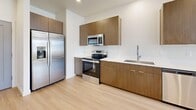 This 1-bedroom, 1-bathroom unit in Bluffdale, Utah, offers a thoughtfully designed single-level layout that maximizes functionality and comfort. The open-concept living area seamlessly connects the living room, dining space, and kitchen, all finished with light hardwood-style flooring that enhances the bright, airy atmosphere created by recessed lighting throughout.

The kitchen is a standout feature, outfitted with warm wood-toned cabinetry, clean white countertops, and a full suite of stainless steel appliances including a refrigerator with ice maker, electric range, microwave, and dishwasher. A wall-mounted mini-split air conditioning unit ensures efficient climate control in both the main living area and the bedroom.

The bedroom offers a comfortable retreat with plush carpeting, a window framing scenic mountain views, and a spacious walk-in closet with built-in shelving for ample storage. The bathroom is clean and functional, featuring a full tub-shower combination with light hardwood-style flooring consistent with the rest of the unit.

Neutral wall tones and a clean, contemporary aesthetic create a cohesive and welcoming environment throughout. This unit combines modern finishes with practical design, making it an efficient and attractive living space.