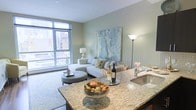 Located at 521 S Broad Street in Philadelphia, PA, this stylish single-floor residence offers a refined urban living experience in one of the city's most vibrant corridors. The open-concept layout seamlessly connects the kitchen and living areas, creating a spacious and cohesive flow throughout the home. The kitchen is appointed with elegant granite countertops, a stainless steel sink, and ample counter space, making it as functional as it is visually appealing. The living area is bathed in natural light streaming through expansive floor-to-ceiling windows, offering dynamic views of the surrounding Philadelphia cityscape. Soft, neutral wall tones and contemporary furnishings contribute to a calm, sophisticated ambiance. A large-scale abstract artwork anchors the living room, adding a curated artistic touch to the space. The wide windows not only maximize light but also create a strong visual connection to the urban environment outside. Overall, this residence strikes a balance between modern design and comfortable livability, making it an ideal space for those seeking a polished city lifestyle in the heart of Philadelphia's South Broad Street neighborhood.