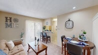 This thoughtfully designed one-bedroom, one-bathroom unit in Metairie, Louisiana makes excellent use of its compact footprint across a single floor. A welcoming entry hallway with tile flooring leads into the main living area, where plush carpet, a textured ceiling, and a wall-unit HVAC system create a cozy atmosphere. The living room accommodates a full seating arrangement and features a sliding glass door that floods the space with natural light and provides outdoor access. Adjacent to the living room, a defined dining nook with recessed lighting offers an intimate space for meals. The kitchen features white cabinetry, a full suite of appliances including a refrigerator, electric range, microwave, and dishwasher, along with a breakfast bar that connects to the main living area for added convenience. The bedroom is carpeted and includes a ceiling fan with light fixture, a mirrored sliding-door closet, and a vanity area with built-in sink and cabinetry just outside the bathroom. A dedicated laundry room houses a stacked washer and dryer unit alongside built-in shelving for added storage. Throughout the unit, neutral warm tones and consistent finishes create a cohesive and comfortable living environment.
