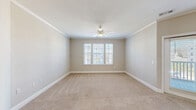 Located at 12000 Sweet Pl in Charleston, SC, this well-appointed single-floor residence offers two bedrooms, two bathrooms, and two closets within a thoughtfully designed layout. The open-concept kitchen and living area serves as the heart of the home, showcasing rich hardwood flooring, crown molding, and pendant lighting. The kitchen is equipped with stainless steel appliances, granite countertops, a subway tile backsplash, white shaker-style cabinetry, and a peninsula with an undermount sink — ideal for both cooking and entertaining. Natural light flows freely through multiple windows fitted with horizontal blinds, brightening the connected living area. Both bedrooms are carpeted and feature ceiling fans, crown molding, and ample natural light from large windows. The spacious primary bedroom includes a dedicated walk-in closet with wire shelving for organized storage. The primary bathroom is a standout, offering dual sinks set in granite countertops, white cabinetry, hardwood floors, a glass-enclosed shower, and elegant vanity lighting. The second bathroom provides additional convenience. Throughout the residence, a neutral color palette and consistent finishes create a clean, cohesive aesthetic that is both functional and inviting.