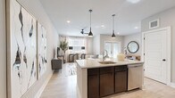 This single-floor residence in Little Rock, Arkansas offers a thoughtfully designed open-concept layout that seamlessly connects the kitchen, dining, and living areas. The kitchen serves as the heart of the space, featuring a large central island with granite countertops, a deep undermount sink, dark cabinetry, stainless steel appliances, and a classic subway tile backsplash. Elegant pendant lights hang above the island, complementing the recessed lighting throughout. Light wood-look flooring flows across the main living areas, enhancing the bright, airy atmosphere created by large windows dressed with sheer curtains.

The living room is generously sized, with a ceiling fan, ample natural light, and direct access to a glass-paned exterior door. The bedrooms are carpeted for comfort and warmth, each offering natural light through well-positioned windows. The full bathroom features granite countertops, dark cabinetry, a large vanity mirror, and a glass-enclosed shower and tub combination with light tile flooring.

A dedicated laundry room includes a full-size washer and dryer alongside extensive wire shelving for organized storage. Throughout the residence, neutral tones, clean lines, and contemporary finishes create a cohesive, modern aesthetic that is both functional and inviting.