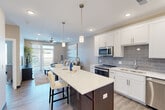 Located on Eventide Drive in Shiloh, Illinois, this thoughtfully designed one-bedroom, one-bathroom residence offers a cohesive open-concept layout finished with modern, neutral-toned interiors throughout. Light wood-style flooring runs continuously across the space, enhancing the sense of flow and continuity.

The kitchen is a standout feature, showcasing white shaker cabinetry, a gray subway tile backsplash, quartz countertops, stainless steel appliances, and a large center island with seating — ideal for casual dining or entertaining. A built-in desk area with matching cabinetry provides a functional workspace just off the kitchen.

The living room is bright and welcoming, with a ceiling fan, recessed lighting, and a sliding glass door that opens to a private balcony, allowing natural light to fill the space and offering outdoor views.

The bedroom is a comfortable retreat featuring a ceiling fan, a generously sized window for natural light, and access to the full bathroom. The bathroom is well-appointed with a dual-sink vanity topped with quartz, wood-style flooring, a glass-enclosed shower, and direct access to a dedicated walk-in closet with built-in shelving.

A hallway connects the main living areas to the private quarters, completing this efficiently designed and attractively finished residence in Shiloh, IL.