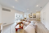 Located at 137 Texas Road in Marlboro Township, NJ, this contemporary multi-level residence spans three floors and offers a thoughtfully designed layout with 1 bedroom and 2 full bathrooms. Light wood-toned flooring and crisp white walls flow throughout, creating a bright and cohesive aesthetic. The main living level features an open-concept kitchen and living room, where a sleek kitchen island with quartz countertops and bar seating serves as a central hub. Stainless steel appliances, flat-panel cabinetry in a warm wood finish, and a wall-mounted range hood complete the modern kitchen. The adjacent living area opens to a private balcony through sliding glass doors, allowing natural light to pour in. The generously sized primary bedroom occupies its own level, offering a serene retreat with large windows, recessed lighting, light hardwood floors, and a dedicated closet. Two well-appointed bathrooms feature clean-lined vanities with wood cabinetry, one with a glass-enclosed walk-in shower dressed in elegant tile, and the other with a glass-enclosed soaking tub. Connecting each floor are clean white staircases with natural wood-toned treads. The lower entry level provides additional functional space, completing this well-organized and stylishly finished home.