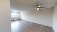 Located at 414 N Forest Park Blvd in Knoxville, Tennessee, this single-floor unit offers a practical and well-organized layout across several distinct living areas. The expansive living room is a standout feature, showcasing light-toned hardwood-style flooring, neutral white walls, a textured ceiling, and a ceiling fan with built-in lighting. Multiple windows fitted with horizontal blinds allow generous natural light to fill the space, while a baseboard heating unit ensures year-round comfort.

The galley-style kitchen is efficiently designed with light wood cabinetry lining both sides, black appliances including a gas range, microwave, and refrigerator, a single-basin sink with a modern faucet, and in-unit laundry conveniently positioned at the far end. Light countertops and hardwood-style flooring complete the clean, functional aesthetic.

The bedrooms are carpeted and feature neutral tones, textured ceilings, and windows that bring in natural light. Each bedroom includes a built-in closet with shelving and hanging rods, offering ample storage. The bathroom is straightforward and clean, with a tiled tub-shower combination, chrome fixtures, and a toilet. Throughout the unit, the neutral color palette and consistent finishes create a cohesive, move-in-ready environment.