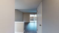 Located at 36000 Fremont Blvd in Fremont, California, this single-floor space offers a clean, modern aesthetic throughout. The entryway opens into a well-connected layout with consistent wood-style flooring that flows through the main living areas, lending a cohesive and polished look.

The living room is a standout feature, highlighted by full-height sliding glass doors fitted with vertical blinds that allow natural light to pour in while providing views of the private outdoor patio area. The open layout creates a comfortable, functional space ideal for everyday living.

The kitchen has been thoughtfully updated with crisp white shaker-style cabinetry, dark countertops, and a full suite of stainless steel appliances including a range, over-the-range microwave, and dishwasher. A stacked washer and dryer unit is conveniently integrated within the kitchen area, adding practical in-unit laundry access.

The bedroom features plush carpeting and benefits from a window with natural light and greenery views, along with an adjacent door providing additional access or closet space. The bathroom includes a full tub-shower combo with a curved curtain rod, chrome fixtures, and a small privacy window for ventilation. Neutral tones and textured ceilings are consistent throughout, completing the space's clean, move-in-ready presentation.