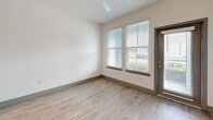 Located at 3951 34th St S in Saint Petersburg, FL, this thoughtfully designed one-bedroom, one-bathroom residence offers a clean, modern aesthetic across a single floor. The open-concept living area seamlessly integrates the kitchen, dining, and living spaces, creating an efficient yet airy layout bathed in natural light from multiple windows fitted with blinds.

The kitchen is a standout feature, showcasing white shaker cabinetry, a herringbone-patterned tile backsplash, granite countertops, and a central island ideal for casual dining. Stainless steel appliances — including a French door refrigerator, range, microwave, and dishwasher — complete the well-appointed space. Elegant pendant lighting and recessed fixtures add warmth overhead.

The bedroom is generously proportioned, featuring light wood-look flooring, a ceiling fan, and dual windows that invite natural light and outdoor views. Two closets provide ample storage throughout the unit. A hallway leads to the in-unit laundry area, adding everyday convenience.

The bathroom is elegantly finished with a granite-topped white vanity, gold-toned hardware, large-format tile flooring, and a soaking tub framed by floor-to-ceiling marble-look tile surround. Light wood-style flooring flows consistently throughout the living spaces, tying the home together with a cohesive, contemporary feel.