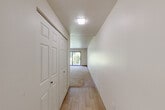 This single-floor, 2-bedroom, 2-bathroom home delivers a thoughtfully organized layout designed for comfortable everyday living. The entrance leads into a hallway finished with light wood-style flooring, setting the tone for the clean, neutral palette carried throughout the space. The open living and dining areas are carpeted and bathed in natural light, with a large sliding glass door in the living room framing a lush, green outdoor view — a standout feature of the home.

The kitchen is efficiently designed, featuring white cabinetry, dark speckled countertops, a stainless steel sink, and white appliances including a gas range and refrigerator. A window above the sink adds natural light to the workspace.

The primary bedroom is generously sized, offering two sets of double sliding closet doors for substantial storage, along with an additional closet — making it one of the most storage-rich rooms in the home. The second bedroom is carpeted with a window overlooking greenery outside. Both bathrooms are clean and functional, with one featuring tile flooring, a single vanity with a mirrored medicine cabinet, and a tiled shower. Throughout the home, textured ceilings, neutral walls, and carpeted floors create a cohesive, move-in-ready environment.