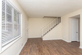 Located at 600 Redmond Rd NW in Rome, Georgia, this two-story home offers a well-organized layout spread across two distinct levels. The main floor features rich, dark hardwood flooring that runs throughout the living areas, complemented by neutral-toned walls and clean white baseboards that give the space a polished, cohesive look. A staircase with white metal railings connects the floors, serving as a functional and visually clean architectural element.

The kitchen is a standout feature, showcasing grey-toned cabinetry with brushed nickel hardware, stone-look countertops, a black electric range, and a decorative mosaic tile backsplash in warm earth tones that adds texture and character to the space.

The upper level transitions to wall-to-wall carpet in the bedrooms, offering a softer, more comfortable feel. The bedrooms are generously proportioned, with neutral walls and access to closet spaces. Windows fitted with horizontal blinds allow natural light to filter in while maintaining privacy, with views of the surrounding greenery visible from within.

Overall, the home presents a clean, move-in-ready aesthetic with practical finishes throughout, balancing functional design with comfortable living spaces across both floors.