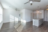 Located at 1133 Commerce Dr in Decatur, GA, this single-floor unit offers a well-designed layout that balances modern finishes with functional living spaces. The kitchen serves as a standout feature, showcasing light-toned flat-front cabinetry, granite countertops, a sleek tile backsplash, and a full suite of stainless steel appliances including a French door refrigerator with ice maker, electric range, built-in microwave, and dishwasher. Rich hardwood-style flooring flows throughout the main living areas, lending warmth and continuity to the space. The living area is bright and open, benefiting from natural light through a window with blinds and a ceiling fan overhead, providing both comfort and airflow. A louvered closet door adds a classic touch to the room's understated design. The bathroom features a tub-shower combination with clean white subway tile surround and brushed gold fixtures, complemented by a well-lit vanity with ample counter space. Adjacent to the bath, a carpeted walk-in closet with wire shelving offers generous storage. The overall aesthetic is clean and contemporary, making this Decatur residence a polished and practical space.