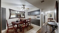 Located at 1612 W 22nd St N in Wichita, Kansas, this single-floor, 2-bedroom, 1-bathroom home offers a well-organized layout across a comfortable footprint. The living room features hardwood-style flooring, a sliding glass door that floods the space with natural light and provides outdoor access, and ample room for seating. The combined kitchen and dining area is a functional highlight, showcasing dark gray cabinetry with brass hardware, light countertops, a double sink, and white appliances including a dishwasher, range, and refrigerator. The adjoining dining space accommodates a full dining set and is accented by a ceiling fan and a large decorative mirror. The primary bedroom offers carpeted flooring, a ceiling fan, and a window with blinds and drapery, providing a calm and restful retreat. The second bedroom is similarly comfortable, with a window allowing natural light. The bathroom includes a single-sink vanity with matching dark cabinetry, a wall mirror, and a combined tub and shower. With four closets distributed throughout, storage is plentiful. The home's consistent use of neutral tones, tile flooring in wet areas, and wood-style flooring in common areas creates a cohesive and practical interior throughout.