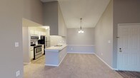 Located at 9991 Arbor Montgomery Ln in Cincinnati, Ohio, this single-floor residence offers a well-organized layout with a variety of functional and comfortable spaces. The living room serves as the heart of the home, featuring a tile-surround fireplace, a ceiling fan, and a sliding glass door that opens to the outdoors, flooding the room with natural light. Neutral-toned carpet and soft gray walls create a clean, cohesive aesthetic throughout.

The dining area connects seamlessly to the living space and kitchen, benefiting from soaring vaulted ceilings and an elegant pendant light fixture that adds a touch of character. A half-wall peninsula delineates the galley-style kitchen, which is equipped with a full suite of appliances including a refrigerator, electric range, microwave, and dishwasher. Light wood-tone flooring, white cabinetry, and track lighting give the kitchen a bright, practical feel.

The bedrooms are generously sized, each finished with plush carpet and featuring windows with blinds that provide natural light and privacy. One bedroom includes access to a walk-in closet and an adjacent bathroom. The bathroom is finished with wood-look vinyl flooring, a combined tub and shower, a single vanity, and crisp white fixtures. The hallway connecting the rooms provides additional closet storage, completing a thoughtfully arranged living space.
