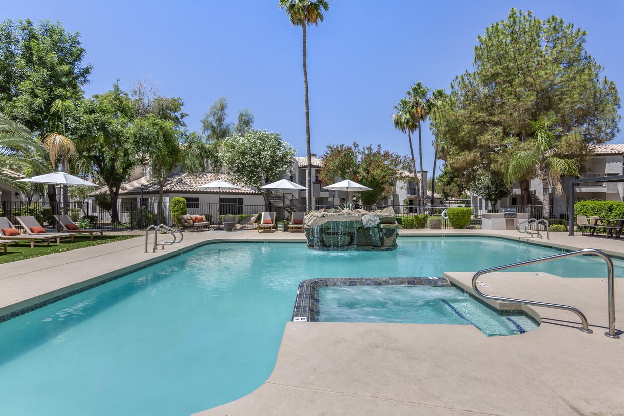 Dive into luxury at Boulders at Lookout Mountain's pool oasis, complete with a stunning fountain and palm tree backdrop - Boulders at Lookout Mountain Apartment Homes